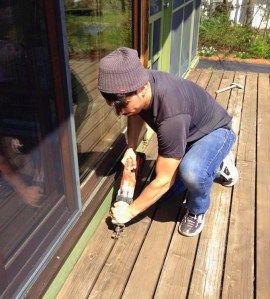 Carpenter Mike Roldan cuts the through nails on Deck House Balcony here using a sawzall a grinder with a metal cutting wheel is also convenient for this task. The decks on these houses are constructed of 3x6" solid cedar timbers. They are fastened to each other with long nails through the sides of the boards and span eight feet without intermediate support on the finished decks. The deck surfaces on a Deck House which has been built to specification perform greater structural work than on a conventional stick framed deck. Their removal should be conducted with care to avoid injury or damage.